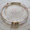Slender twisted guitar string bangle with gold beads and peg still intact