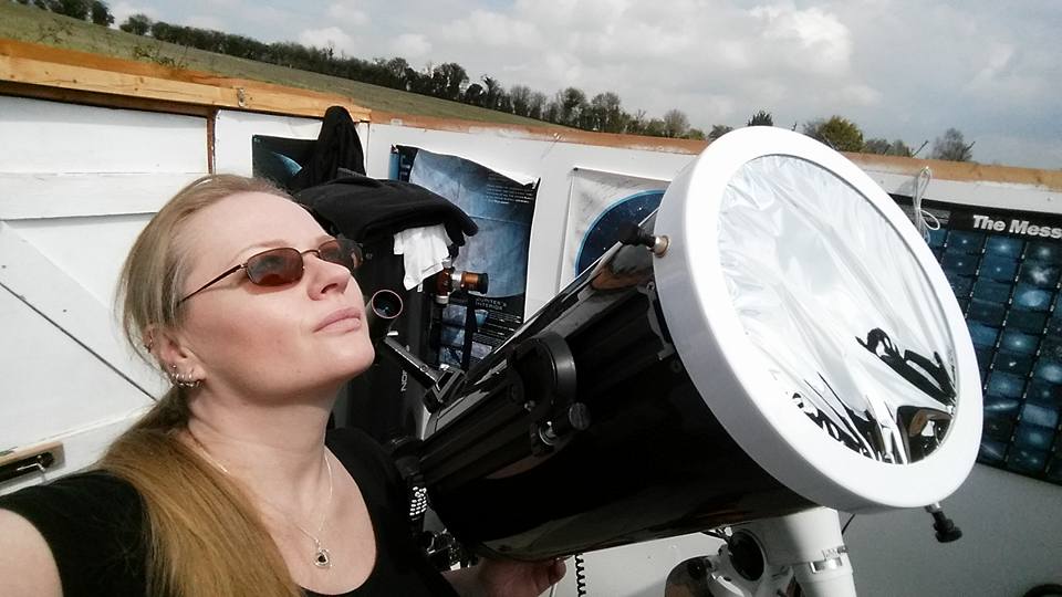 Mary sitting in her home observatory next to an 8" Ritchie-Chretien telescope fitted with a white light solar filter. 