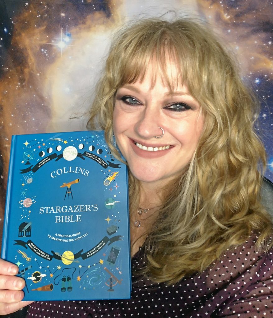 Photo of Mary holding up a copy of the Collin's Stargazer's Bible